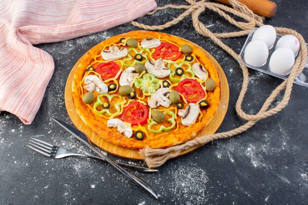 Top view mushroom pizza with tomatoes olives mushrooms along with eggs on the grey desk pizza dough italian food