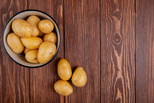 Top view of new potatoes in bowl on wood with copy space