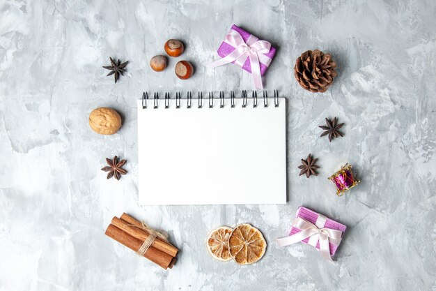 Top view notebook cinnamon sticks dried lemon slices anises on grey background