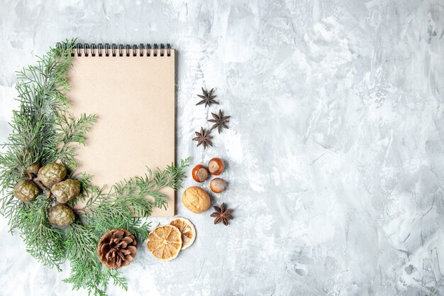 Top view notebook dried lemon slices anises pine tree branches on grey background