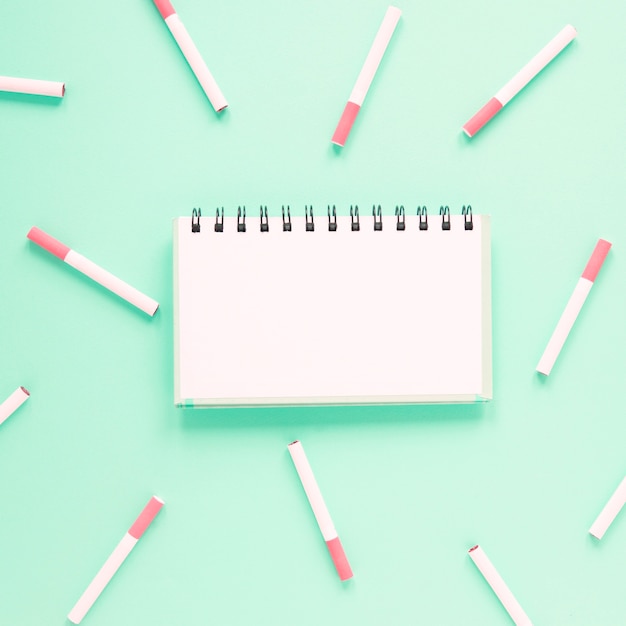 Top view notebook surrounded by cigarettes