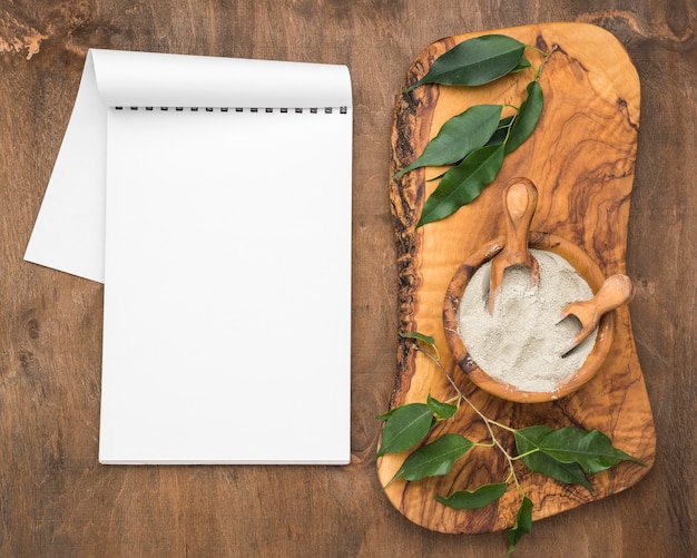 Top view of notebook with bowl of powder and scoops