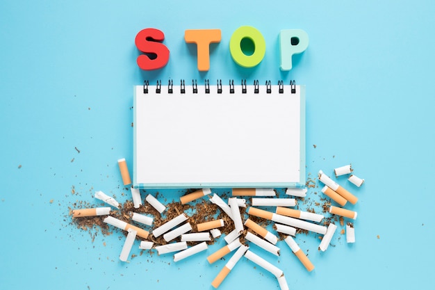 Free photo top view notebook with colorful word and cigarettes