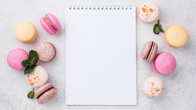 Top view of notebook with macarons and mint