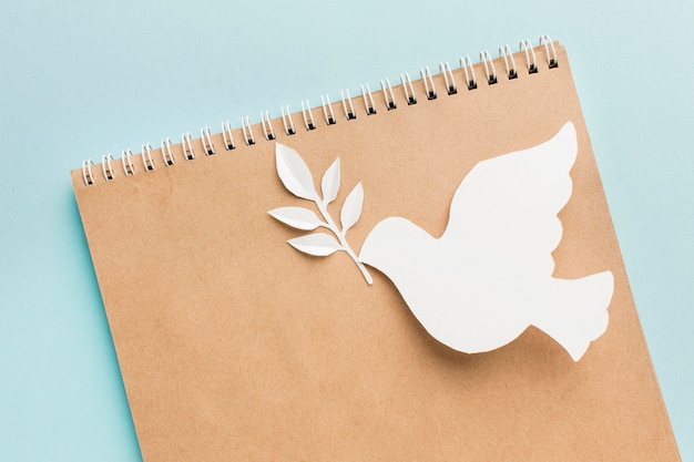 Free photo top view of notebook with paper dove