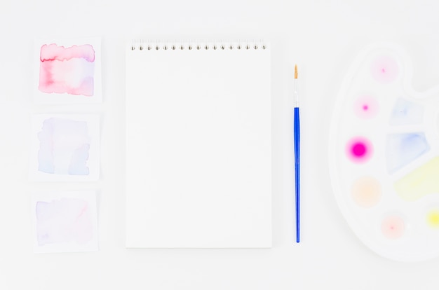 Free photo top view notebook with watercolor and brush