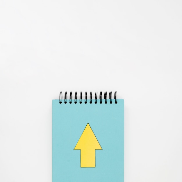 Free photo top view of notebook with yellow arrow