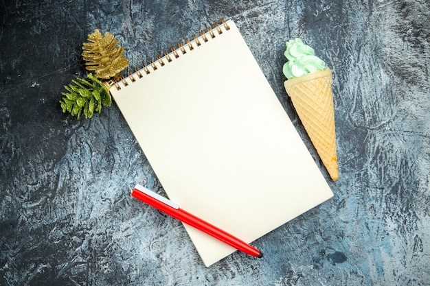 Free photo top view a notebook xmas details red pen ice cream on dark background