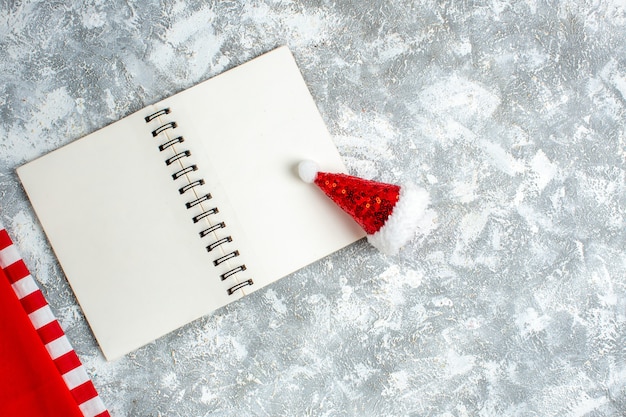 Top view notebook xmas hat toy on grey white table free space