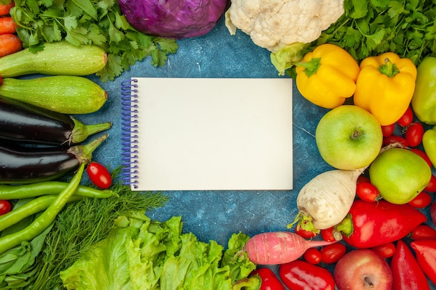 Top view notebook zucchini cherry tomato dill aubergine coriander parsley radish apples lettuce cauliflower bell peppers