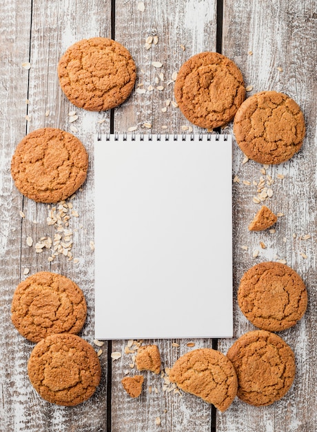 Free Photo top view notepad surrounded by cookies