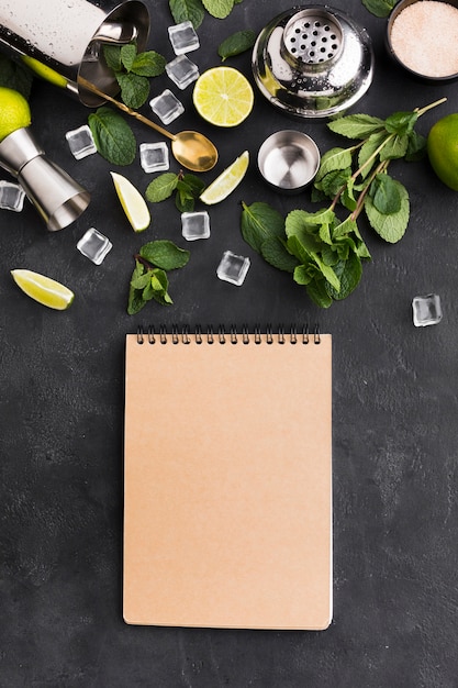 Free photo top view of notepad with cocktail essentials and ice cubes