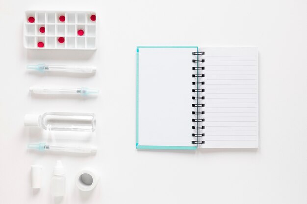 Top view notepad with painkillers and medicine on the table