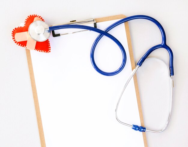 Top view of notepad with stethoscope and damaged heart shape