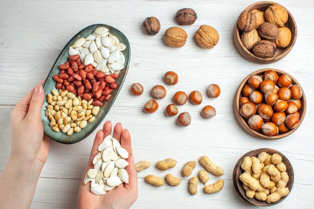 Top view nut composition peanuts seeds hazelnuts and walnuts on white table