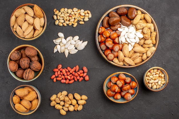 Top view of nut composition with different fresh nuts on a dark surface