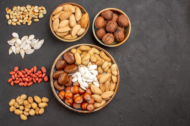 Top view of nut composition with different fresh nuts on dark surface