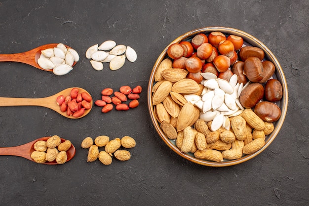 Free photo top view of nut composition with different nuts on dark surface