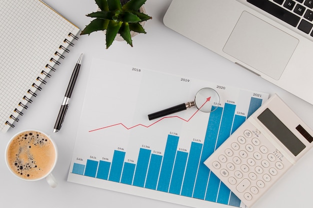 Top view of office desk with growth chart and calculator