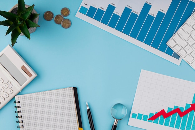 Top view of office desk with growth chart and coins