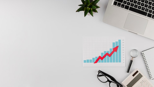 Top view of office desk with growth chart and copy space