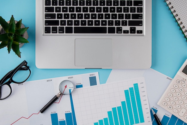 Top view of office desk with growth chart and laptop device