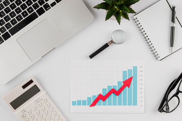 Free Photo top view of office desk with growth chart and laptop