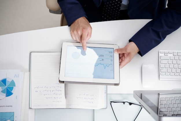 Free Photo top view of office desktop with notebook, documents, computer and digital tablet used by anonymous man