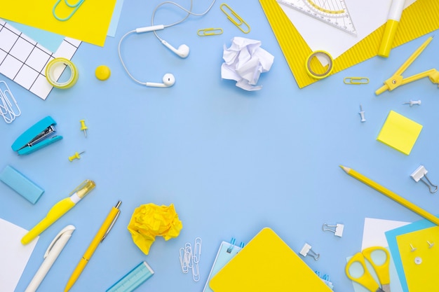 Top view of office stationery with earphones and stapler