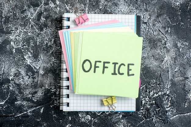 top view office written note with colorful stickers and copybook on gray background