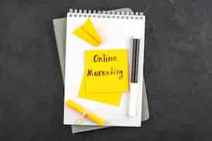 Free photo top view online marketing written on sticky note black marker on notepad on dark background