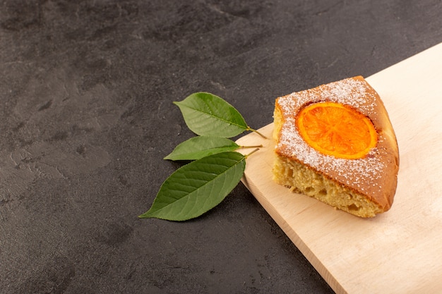 A top view orange cake slice sweet delicious tasty on the cream colored wooden desk and grey background sweet sugar biscuit