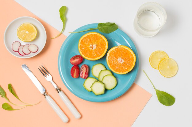 Top view organic oranges and veggies on a plate