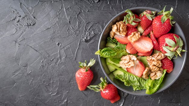 Top view organic salad with walnuts and strawberries