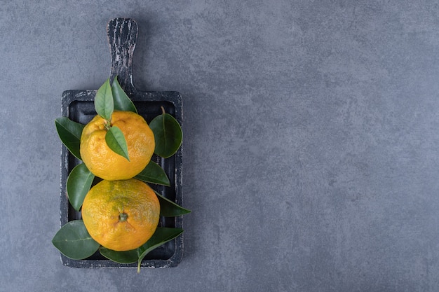 Free photo top view of organic tangerines on black wooden board.