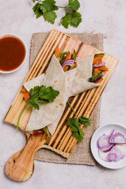 Top view of organic vegetables wrapped in pita with onion