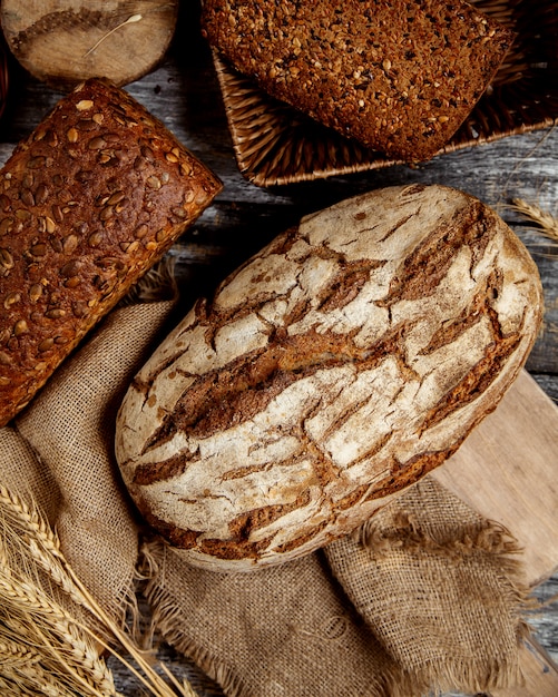 Top view of organic whole grain breads placed on linen fabric