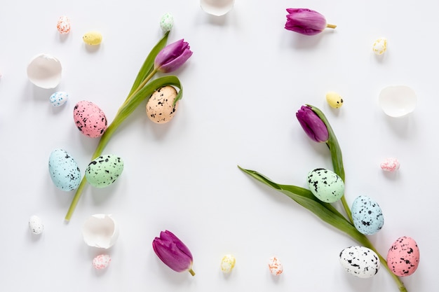 Free photo top view painted eggs and flowers on table