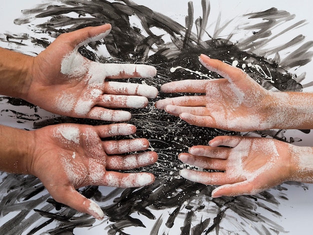 Free photo top view of pair of hands covered in white paint