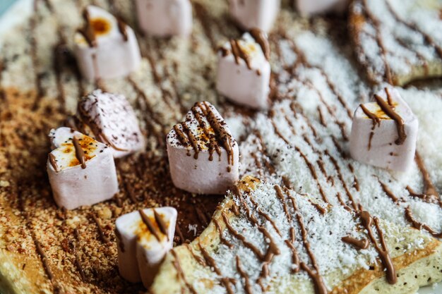 Top view pancakes with marshmallow and chocolate icing with coconut flakes