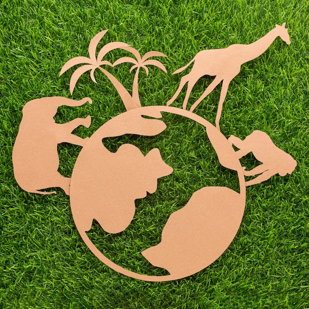 Free photo top view of paper animals and planet on grass for animal day