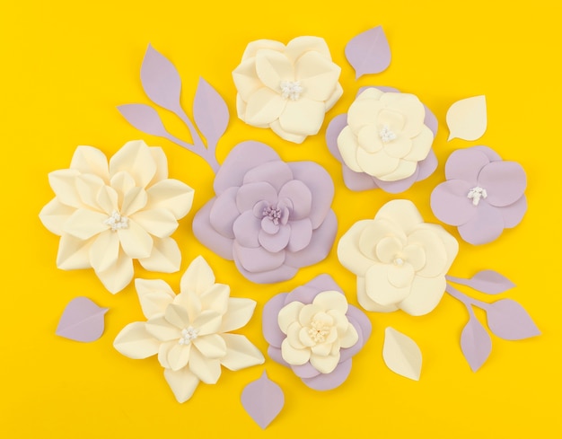 Free photo top view paper flowers on yellow background