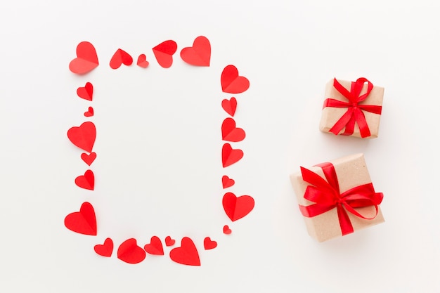 Free Photo top view of paper hearts frame with presents