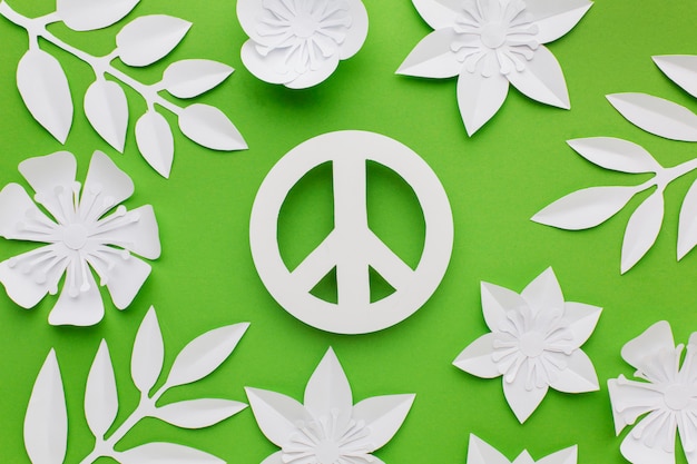 Top view of paper peace sign with leaves and flowers