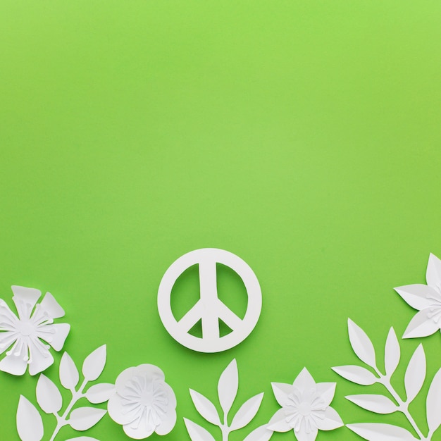 Free photo top view of paper peace sign with leaves