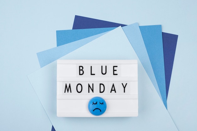 Free photo top view of paper with sad face and light box for blue monday