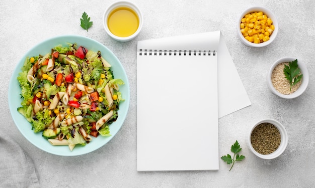 Free photo top view pasta salad with balsamic vinegar and blank notepad