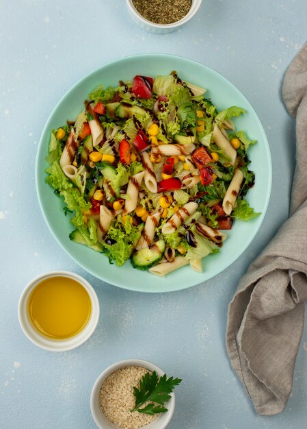 Top view pasta salad with balsamic vinegar, sesame seeds and oil