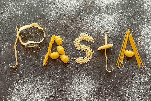 Free photo top view of pasta word on plain background