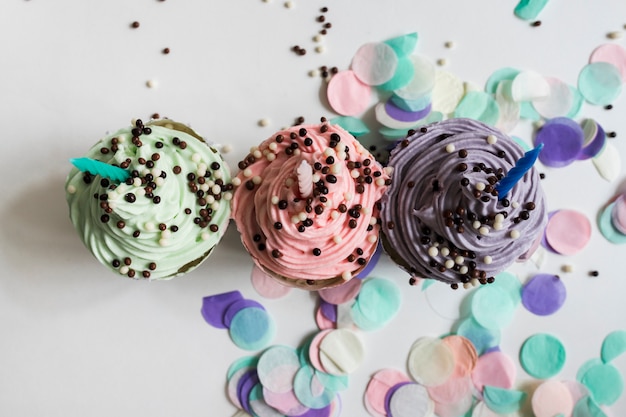 Free Photo top view pastel color cupcakes with chocolate balls with confetti